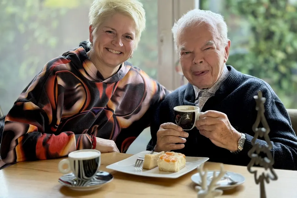 Anja Mattausch mit einem Senior bei Kaffee und Kuchen im Café