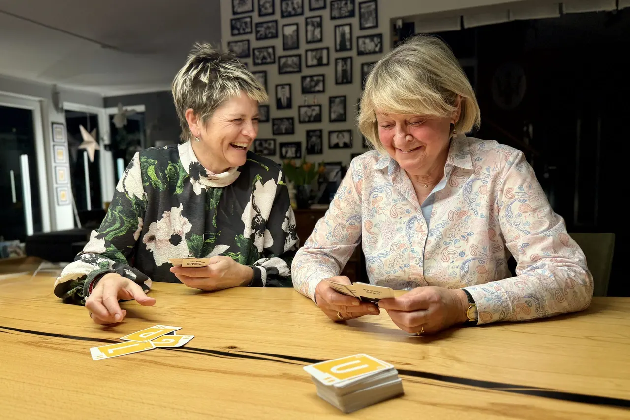 Anja Mattausch und eine Seniorin beim Kartenspielen