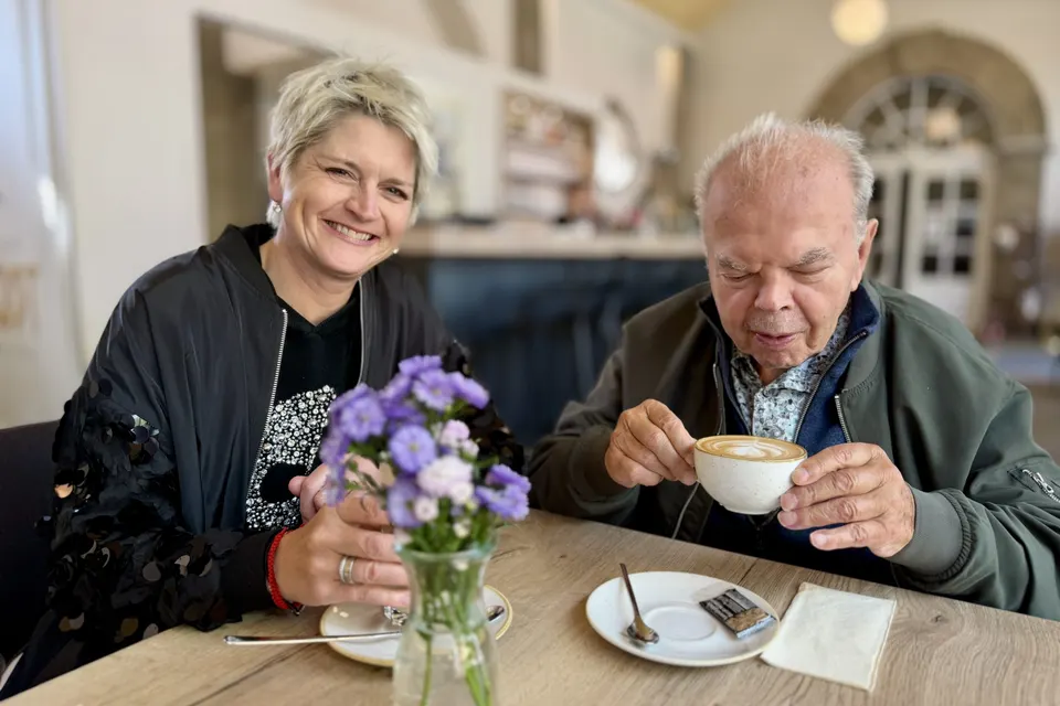 Anja Mattausch mit einem Senior beim Cappuccino im Café